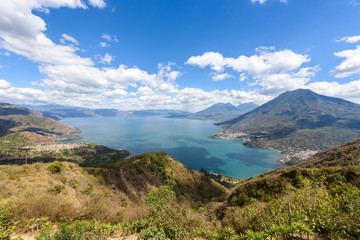 Fototapeta na wymiar Panorama view to the lake Atitlan with volcanos - small villages San Pedro, San Marcos, San Juan and Panajachel at lake Atitlan in the highland of Guatemala