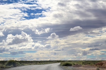cielo azul con nubes  y vegetación en carretera