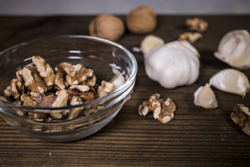 Garlic and walnuts on wooden background