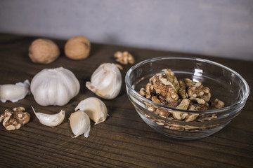 Garlic and walnuts on wooden background