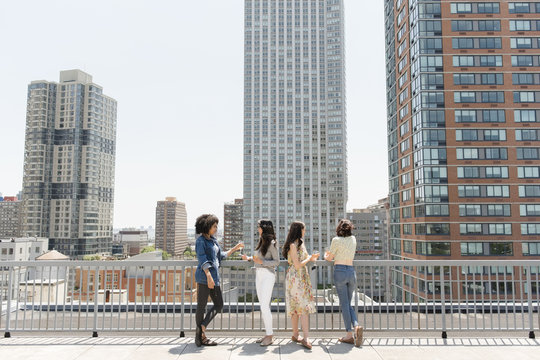 Women drinking wine on urban rooftop