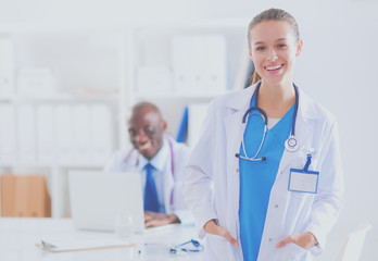 A smiling female doctor with a folder in uniform indoors