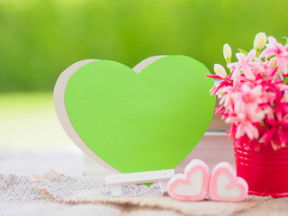 Obraz na płótnie Canvas Poster mock up template with flower bouquet, marshmallow in the shape of heart and books over green background