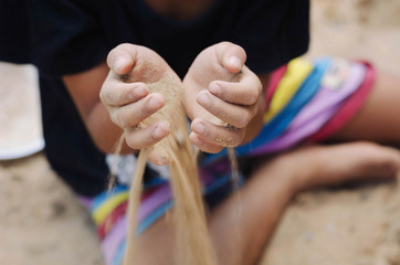  children hand hold sand on beach