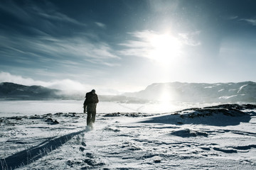 Man traveler with backpack at winter mountain