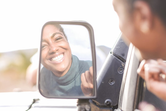 Reflection of African American woman in car mirror
