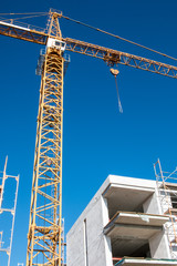 Yellow crane with a building on a construction site