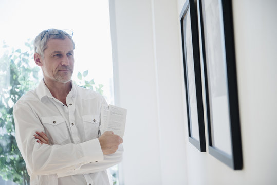 Older Caucasian man admiring artwork in gallery 
