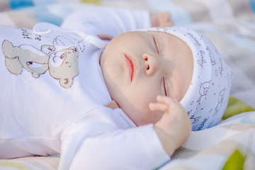 Маленький малыш спит в парке не пледе вечером во время заката. © 89502687345