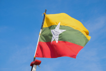 Naklejka na ściany i meble Flag of Myanmar (Burma) with blue sky