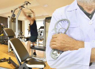 Doctor with stethoscope on fitness room background.