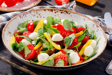 Healthy salad with mozzarella on wooden table.