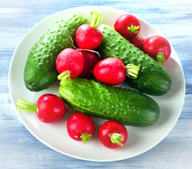 Fresh healthy   radish and cucumbers on  white plate