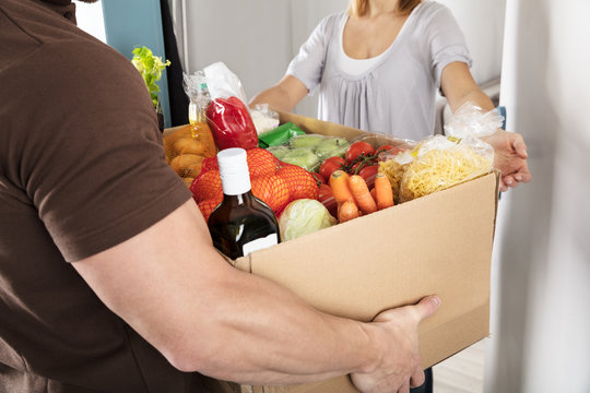 Delivery Man Giving Grocery Box To Woman