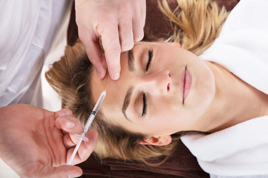 Woman Getting Cosmetic Injection Treatment At Clinic