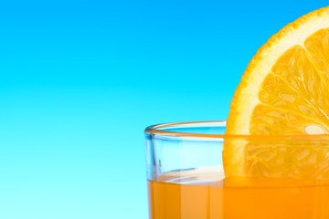 A glass of orange juice on blue background