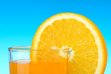 A glass of orange juice on blue background