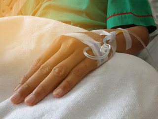 Saline solution on patient hand, light effect.