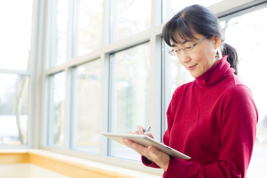 Japanese businesswoman holding pen and digital tablet