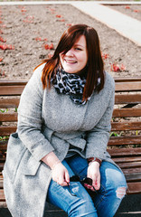 Girl sitting on a bench in a coat