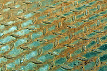 Close-up of rusty metal floor pattern with blur effect.