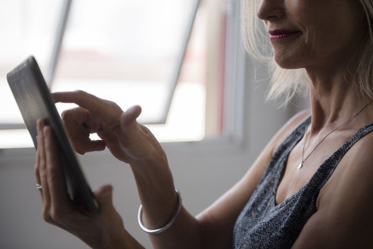 Caucasian woman using digital tablet near window