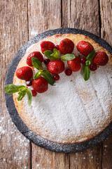 Victoria sandwich cake decorated with strawberries and mint closeup. vertical top view