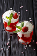 Beautiful strawberry dessert, decorated with hearts and fresh mint close up in a glass. vertical