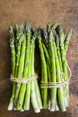 Fresh and raw green asparagus bunches on a vintage background. 