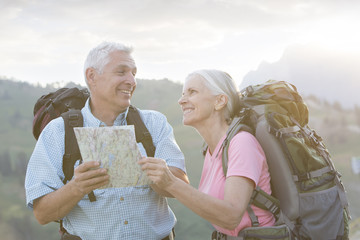 Caucasian couple hiking with map on mountain