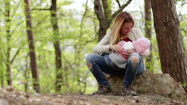 Mother breastfeeding little baby girl in nature's outdoors