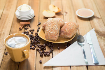Crispy rolls with butter, apple jelly and hot coffee for breakfast