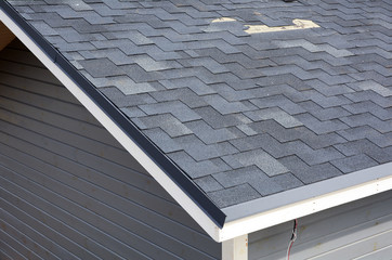 A close up view of shingles a roof damage. Roof Shingles - Roofing. © cherokee4
