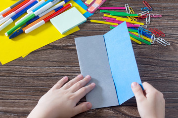 A child is folding an origami paper. Handmade. The project of children's creativity is a children's...