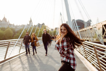 Junge Frau lächelt auf der Brücke in London