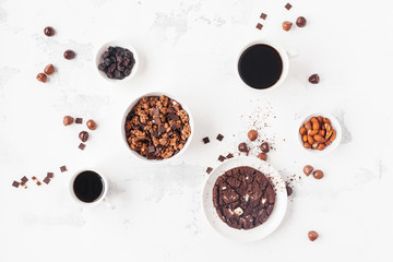 Cups of coffee, chocolate cake, chocolate muesli on white background. Flat lay, top view, copy space