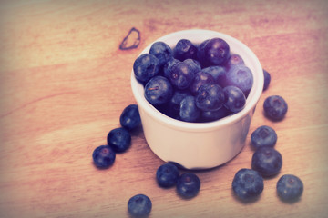 Pot of blueberries on a rustic background