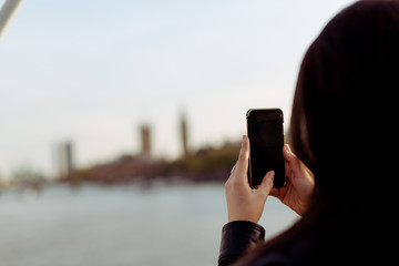 Junge Frau macht ein Bild mit ihrem Mobiltelefon von London
