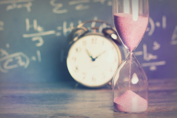 Hourglass on wood with a blackboard background