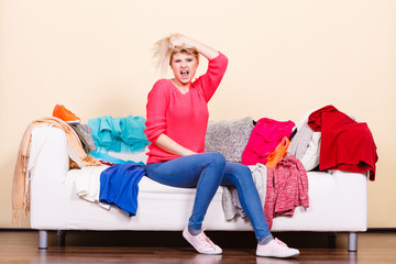 Woman does not know what to wear sitting on couch