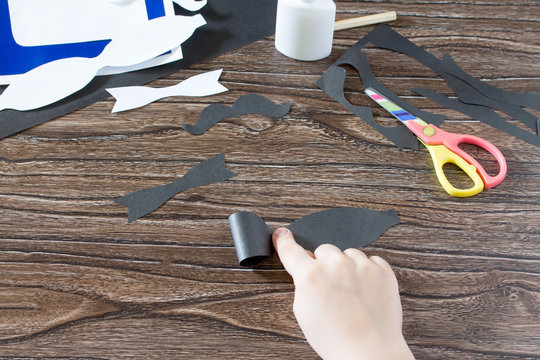 The child glues together the paper parts. Greeting card for Father's Day. Made by own hands. Children's art project, a craft for children. Craft for children.