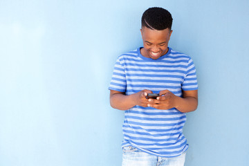 young african man smiling and looking at cellphone