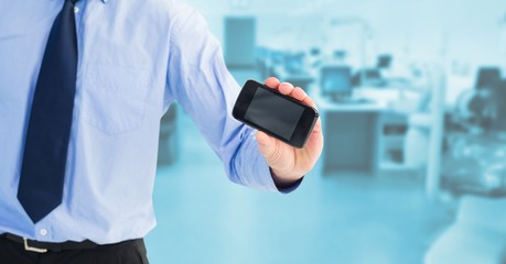 Midsection of businessman showing blank screen on mobile phone