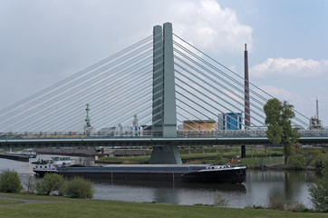 Cargo ship on the main river in front of an industrial area in Frankfurt, Germany