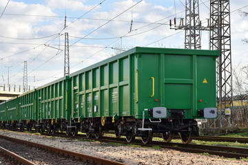 Fototapeta na wymiar Burgas, Bulgaria - March 20, 2017 - Freight cargo train - 4axled box wagon green Type:Eanos Model:155-1 - Transvagon AD