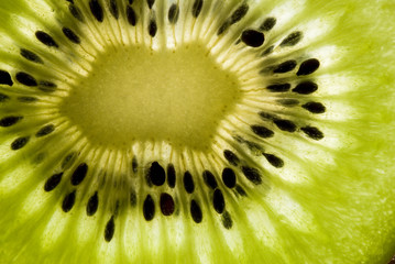 detail of sliced kiwifruit with seeds and light