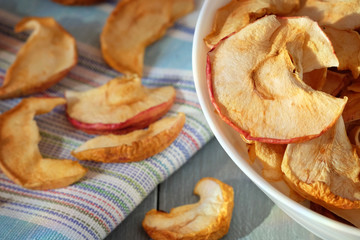 Dried apples on wooden background.