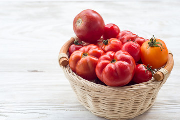 Fototapeta na wymiar Fresh red tomatoes in a basket on a white background