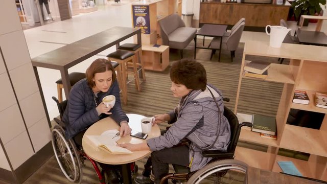 Two physically challenged women in a cafe