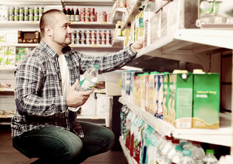 man choosing mineral water in grocery.